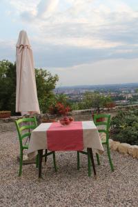 ヴェローナにあるRelais Villa Ambrosettiのテーブルと椅子2脚(パラソル付)