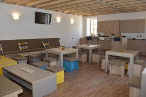 a room with tables and chairs and a kitchen at Hostel Antique in Pula
