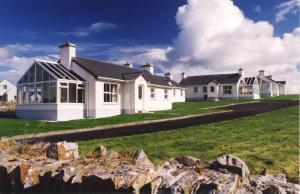 una casa blanca con muchas ventanas en Downings Coastguard Cottages - Type A en Downings