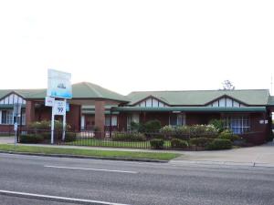 um edifício ao lado de uma rua com uma placa em Bairnsdale Tanjil Motor Inn em Bairnsdale