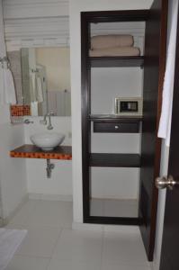 a bathroom with a sink and a toilet and a mirror at Park Hotel in Santa Marta