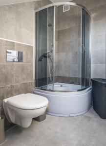 a bathroom with a shower and a toilet and a tub at Na Fali Apartament w Karwi in Karwia