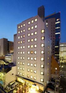 un edificio alto con muchas ventanas en una ciudad en Hotel Pao en Hiroshima