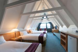 a hotel room with two beds and a window at Heartland Hotel Queenstown in Queenstown