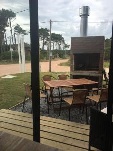 a picnic table and chairs with a fireplace at Pretas in Punta Del Diablo +4 photos
