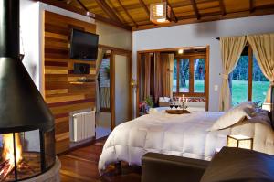 a bedroom with a large bed and a fireplace at Pousada Villa Acauã in Visconde De Maua +58 photos