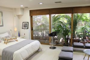 sypialnia z dużym łóżkiem i dużym oknem w obiekcie Luxurious Loft with Garden w Atenach