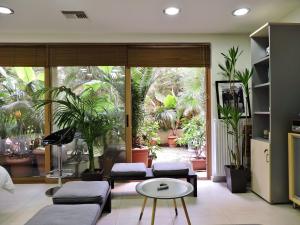 salon z kanapą, stołem i roślinami w obiekcie Luxurious Loft with Garden w Atenach