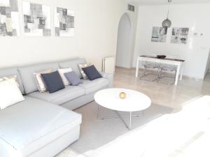 マルベーリャにあるApartamento en Marbellaの白いリビングルーム(ソファ、テーブル付)