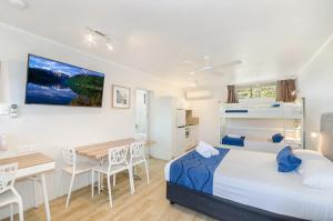 1 dormitorio con cama, escritorio y mesa en Beach House Motel, en Townsville