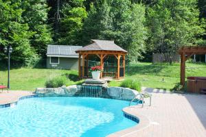 a swimming pool with a gazebo in a yard at The Inn at Quail Run in Wilmington