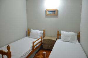 two twin beds in a room with a picture on the wall at Copacabana Etrusco Apartment in Rio de Janeiro