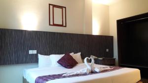 a hotel room with a bed with swans on it at Salsa Resort Langkawi By Casa Loma in Pantai Cenang