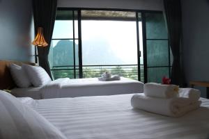 a hotel room with two beds and a large window at Inthira Vangvieng in Vang Vieng +68 photos