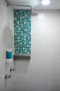 a bathroom with a mirror and a green tiled wall at YY318 Hotel Bukit Bintang in Kuala Lumpur