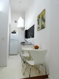 cocina con mesa blanca y sillas blancas en La mejor ubicación en Buenos Aires
