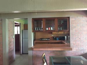 a kitchen with wooden cabinets and a brick wall at Hanalei Gardens in Mae Nam