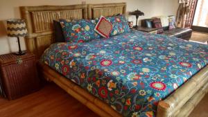 a bed with a blue comforter and pillows at Vinofilia Wine Country Inn in Valle de Guadalupe