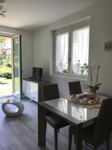 Orchidea Apartment في بيلاجيو: غرفة طعام مع طاولة وكراسي زجاجية