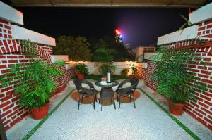 a patio with a table and chairs and plants at Hotel Surabhi Regency in Anand