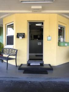 a front door of a building with a bench at Apollo Inn - Cocoa in Cocoa