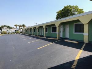 a row of green buildings in a parking lot at Apollo Inn - Cocoa in Cocoa