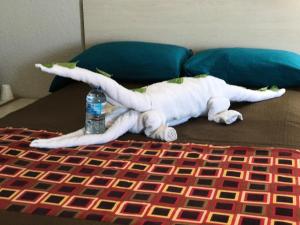 a white stuffed animal laying on a bed with a water bottle at Apollo Inn - Cocoa in Cocoa