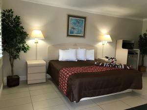 a hotel room with a bed and two lamps at Apollo Inn - Cocoa in Cocoa
