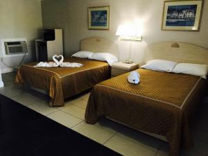 a hotel room with two beds with towels on them at Apollo Inn - Cocoa in Cocoa