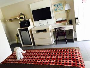 a room with a television and a stuffed animal on a bed at Apollo Inn - Cocoa in Cocoa