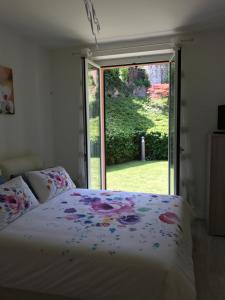 sypialnia z łóżkiem i dużym oknem w obiekcie Orchidea Apartment w mieście Bellagio