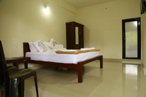 KattappanaSkyrock Inn的卧室里有一张床、一张桌子和一面镜子