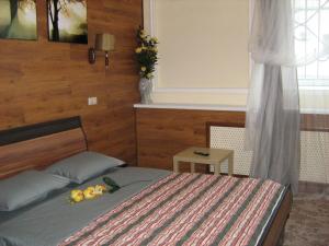 a bedroom with a bed with flowers on it at Hotel Sfera Barnaul in Barnaul