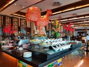 a buffet line with dishes and a rooster in a restaurant at Waterfront Airport Hotel and Casino in Mactan