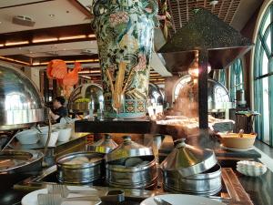 a restaurant with a counter with plates and pans at Waterfront Airport Hotel and Casino in Mactan