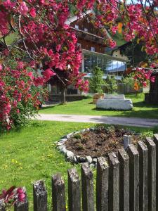 un jardín con una valla frente a un edificio en Landhaus Alpenrose - Feriendomizile Pichler en Heiligenblut