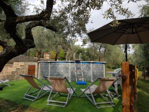 een groep stoelen en een paraplu in een tuin bij Casa vacanze il Redo in Marliana