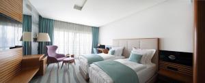 una camera d'albergo con un grande letto e una scrivania di Hotel Navis a Orašje