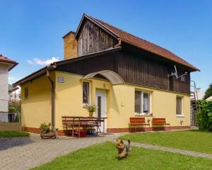 una casa gialla e nera con un cane davanti di Privát Ruženka a Liptovský Mikuláš