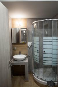 a bathroom with a sink and a glass shower at Pallas Luxury Apartments in Ammouliani