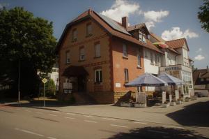 duży ceglany budynek po stronie ulicy w obiekcie Hotel Zur Eisenbahn w mieście Renningen