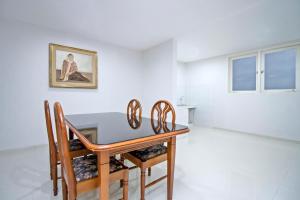 a dining room with a table and chairs at UROOMS Tanah Abang in Jakarta
