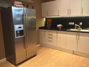 a kitchen with a stainless steel refrigerator and white cabinets at Emmahus in Fürstenau