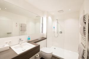 ein weißes Badezimmer mit Waschbecken und Toilette in der Unterkunft Boardinghouse am Wall in Salzgitter-Bad