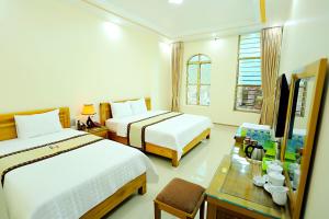 Giường trong phòng chung tại Huy Hoan Hotel