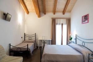 1 dormitorio con 2 camas, mesa y ventana en Agriturismo Chesini, en Castelnuovo del Garda