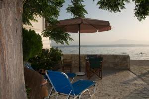 dos sillas y una sombrilla en un patio junto al agua en Iria Bay, en Iria