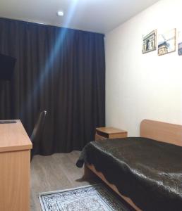 a bedroom with a bed and a black curtain at Timan Hotel in Ukhta