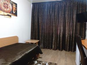a bedroom with a bed and a black curtain at Timan Hotel in Ukhta