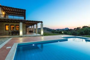 una piscina frente a una casa en Poseidon Villa, nestled in the picturesque south, By ThinkVilla, en Lefkogeia